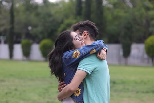 Young couple embracing in a park, illustrating Iowa's four-year gap and its household and authority exceptions