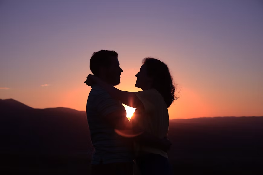 Silhouette of a young couple embracing at sunset, illustrating Texas close-in-age affirmative defense