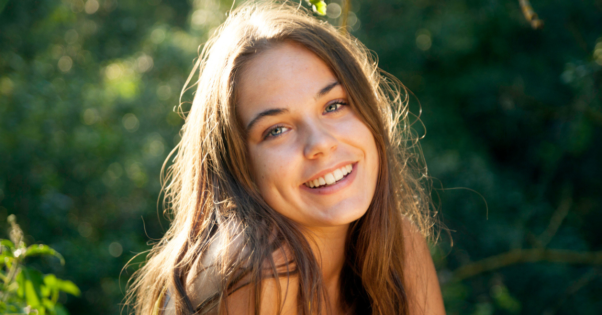 Smiling teenage girl outdoors in sunlight, illustrating that age of consent laws set a legal capacity line rather than a moral judgment