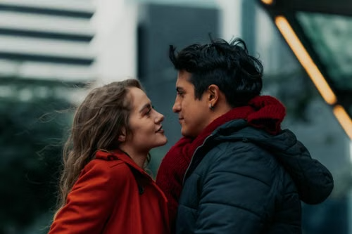 Young couple facing each other on a city street in winter coats, illustrating South Dakota's three-year element