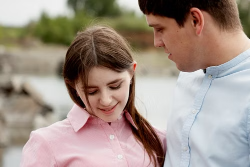 Young couple standing close together outdoors by the water, illustrating New Hampshire's contact-only age-gap rule
